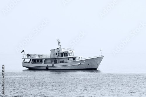 A small ship lying at anchor in the fog