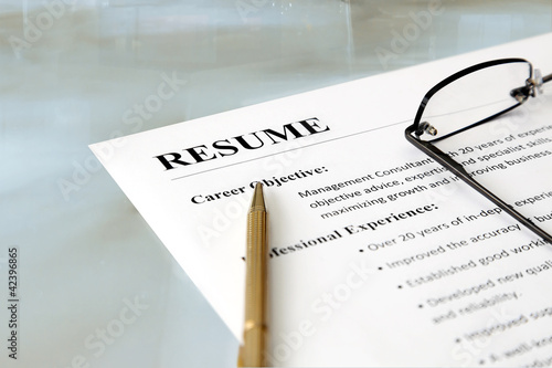 Closeup of resume with pen and glasses on the table