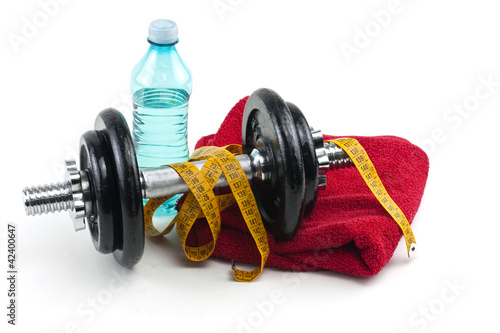 dumbells, water in bottle and towel on white background