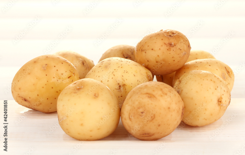 young potatoes on white wooden table close-up young potatoes on white wooden table close-up
