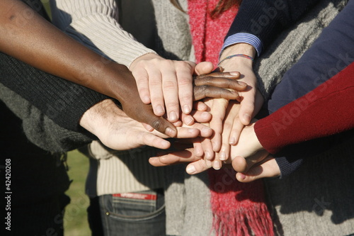 Young group with hands stacked together photo