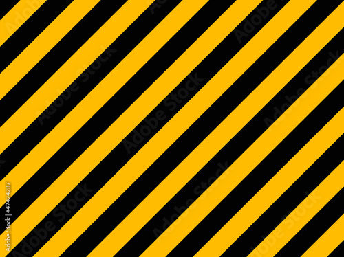 Yellow and black diagonal hazard stripes painted on old brick wa