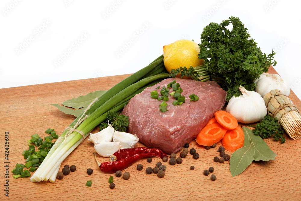 raw meat, vegetables and spices isolated on a wooden table. raw meat, vegetables and spices isolated on a wooden table.