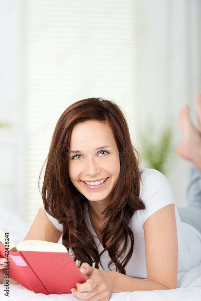 frau liegt auf dem bett und liest frau liegt auf dem bett und liest