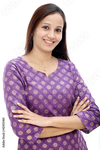 Smiling indian woman with arms crossed against white background