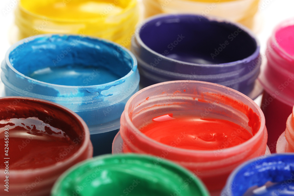 jars with multicolored gouache on white background close-up jars with multicolored gouache on white background close-up