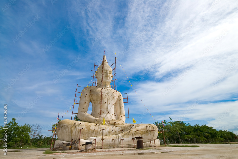 Buddha statue with blue sky and clouds under construction