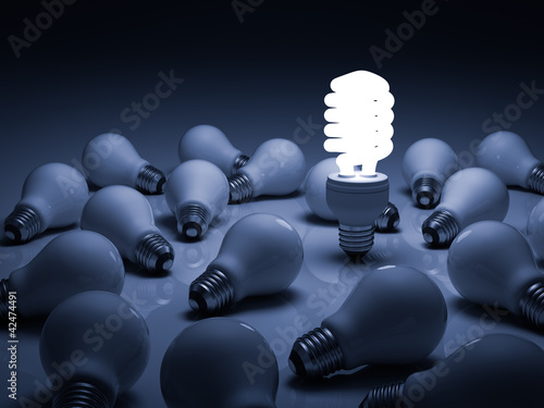 Lit energy saving lightbulb amongst unlit incandescent bulbs