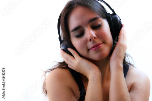Young Woman In Headphones Listening To Music With Eyes Closed