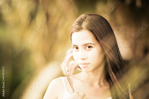 Asian Girl at grass field at sunset. Photo in old image style
