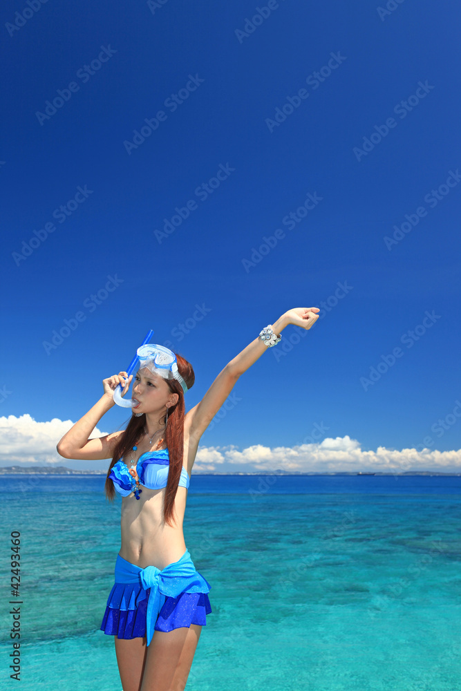澄んだ珊瑚礁の海と引きに姿の女性