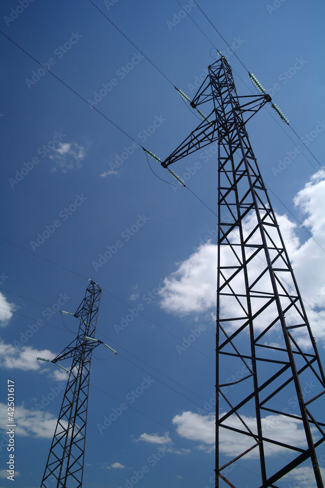 Electricity pylon against blue cloudy sky Electricity pylon against blue cloudy sky