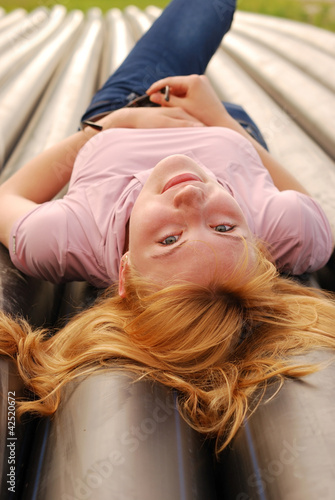 The young beautiful girl lays on pipes
