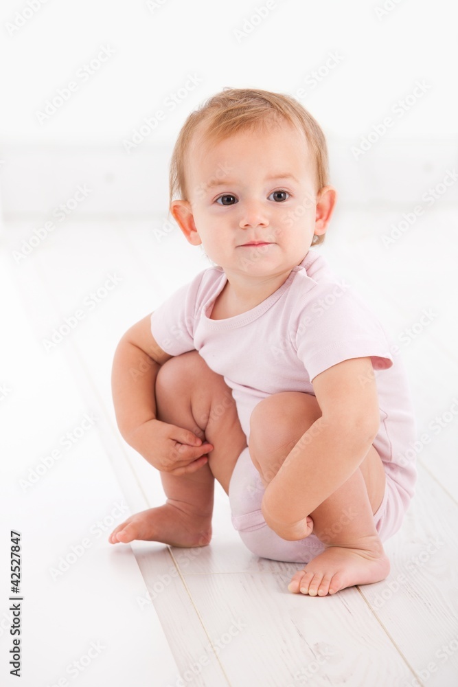 Cute baby girl crouching on floor Cute baby girl crouching on floor