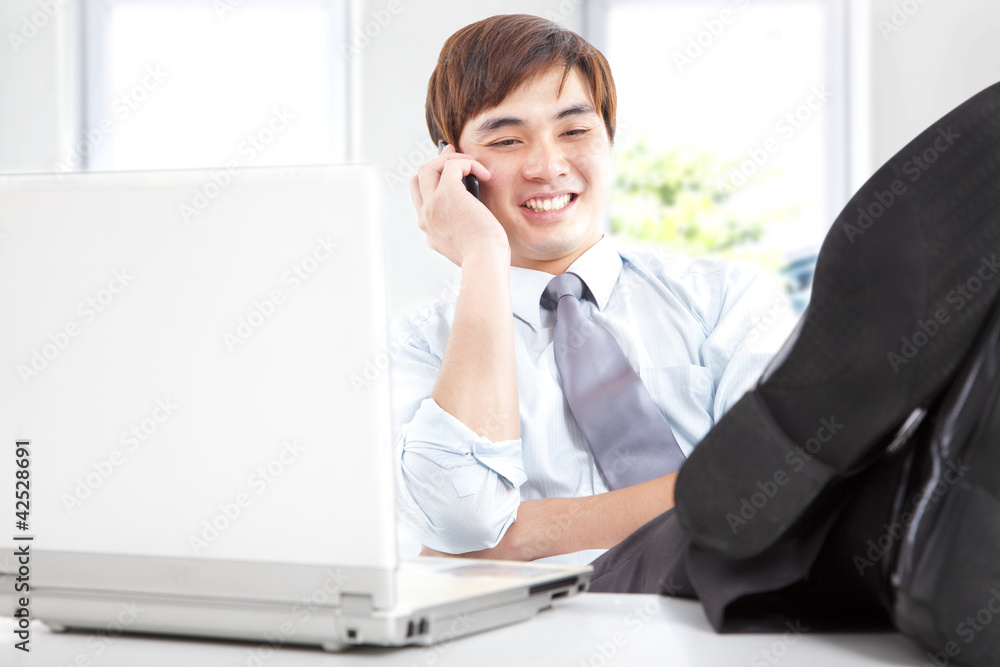 happy businessman taking a phone call in office happy businessman taking a phone call in office