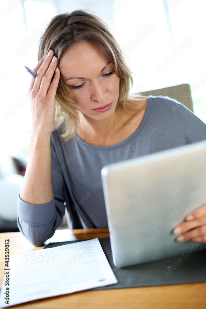 Woman at home having trouble to fill in tax form Woman at home having trouble to fill in tax form