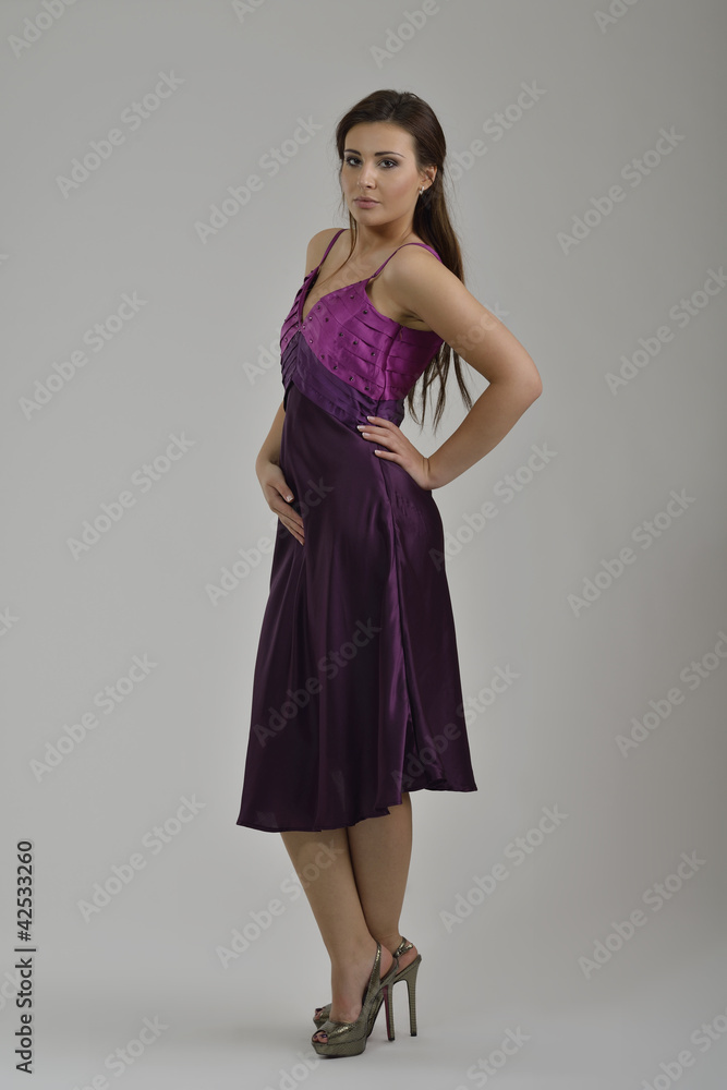 elegant woman in fashionable dress posing in the studio