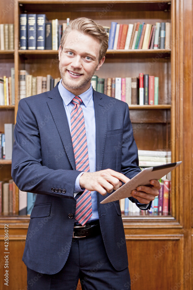 Mann in Bibliothek mit Tablet PC Mann in Bibliothek mit Tablet PC