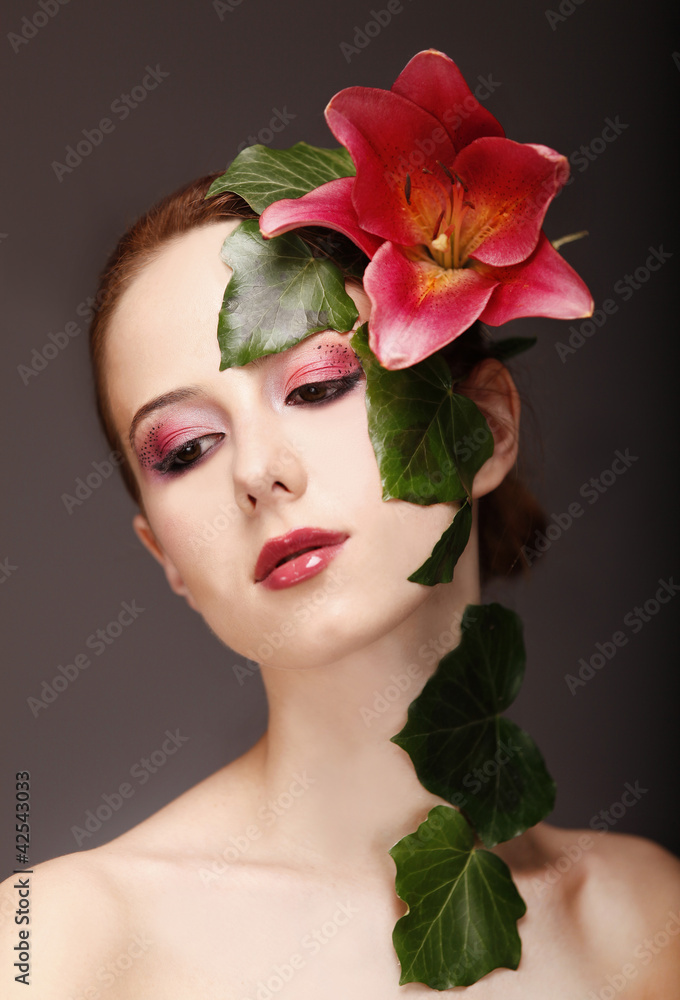 Portrait of red-haired girl with flower and make-up.