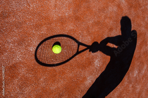 shadow of a tennis player in action on a tennis court  © lightpoet