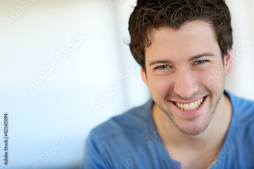 Portrait of cheerful young guy with blue eyes