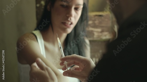 Drugs and people, man helping woman with heroin syringe