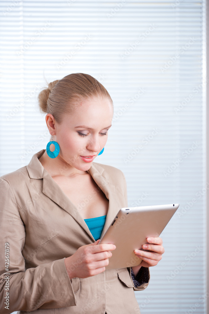 beautiful young positive business woman/student using a tablet o beautiful young positive business woman/student using a tablet o