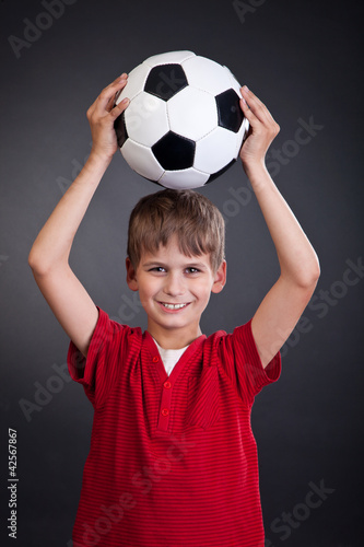 Cute boy is holding a football ball. Soccer ball © Sergii Figurnyi