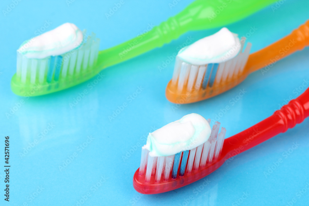 Toothbrushes with paste on blue background Toothbrushes with paste on blue background