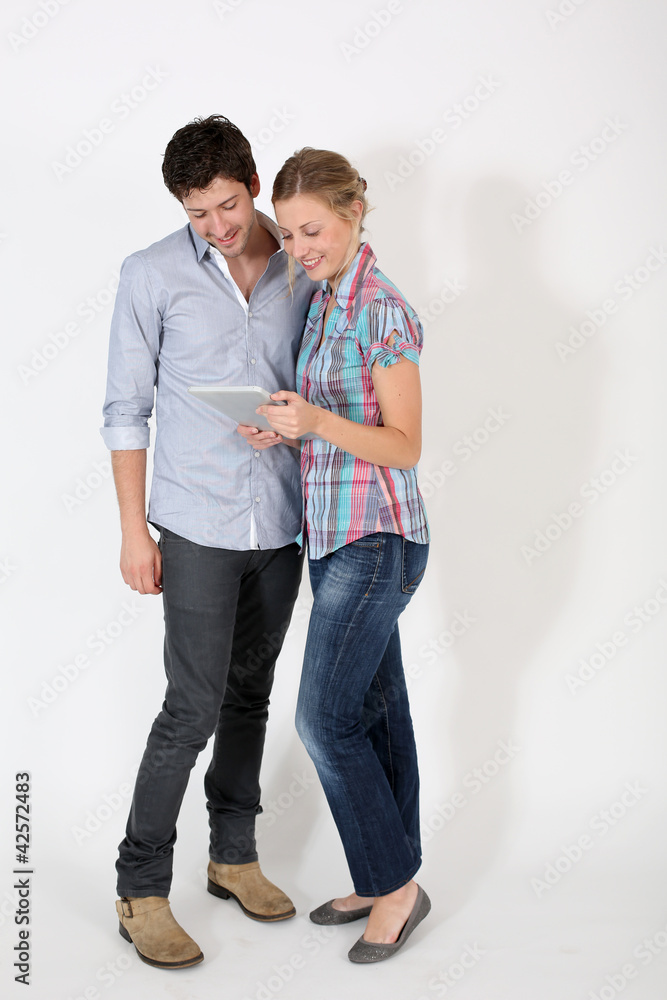Young couple on white background holding digital tablet Young couple on white background holding digital tablet