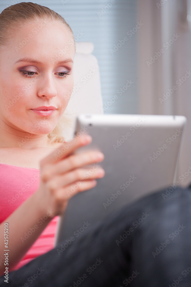 Young beautiful student using a tablet computer while relaxing Young beautiful student using a tablet computer while relaxing