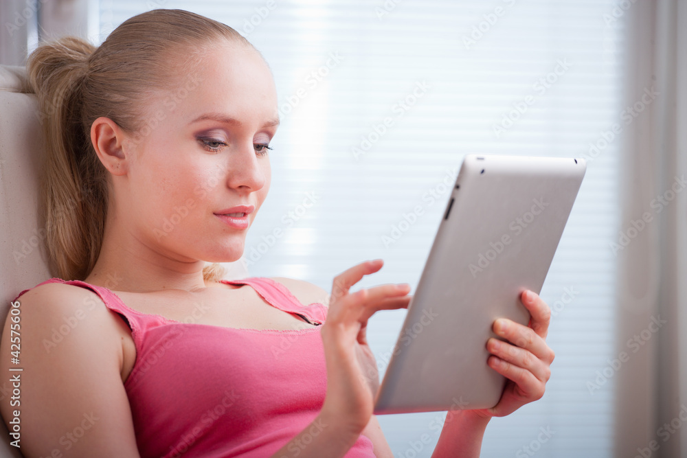 Young beautiful student using a tablet computer while relaxing Young beautiful student using a tablet computer while relaxing