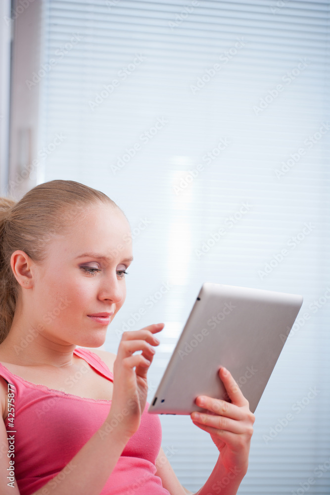 Young beautiful student using a tablet computer while relaxing Young beautiful student using a tablet computer while relaxing