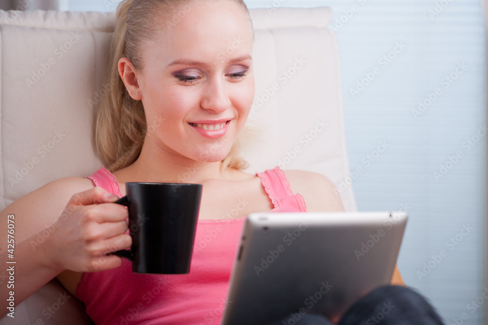Young beautiful student using a tablet computer while relaxing Young beautiful student using a tablet computer while relaxing