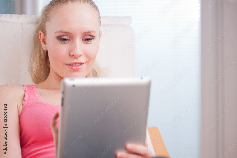 Young beautiful student using a tablet computer while relaxing Young beautiful student using a tablet computer while relaxing