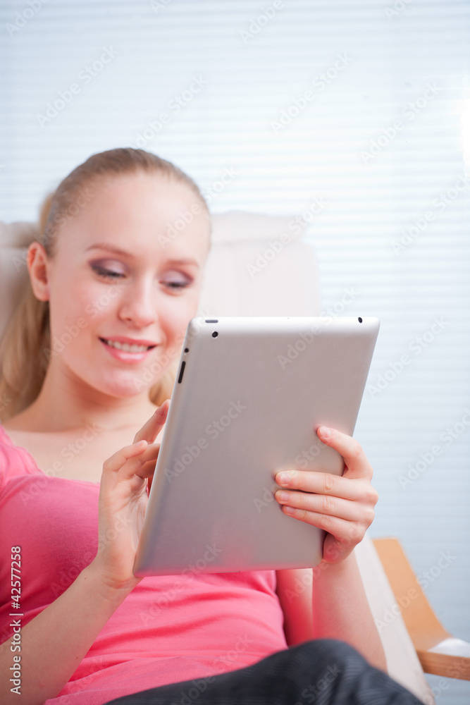 Young beautiful student using a tablet computer while relaxing Young beautiful student using a tablet computer while relaxing