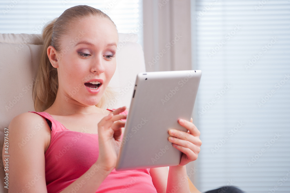 Young beautiful student using a tablet computer while relaxing Young beautiful student using a tablet computer while relaxing