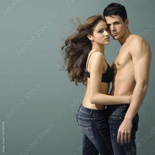 Sexy young couple wearing jeans against in the studio
