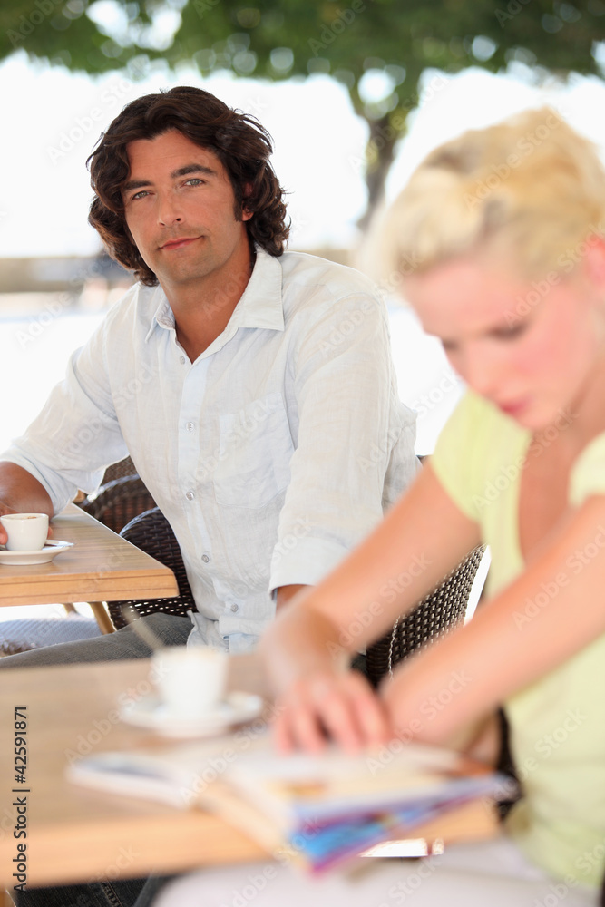Obraz premium Two people drinking coffee on a terrace