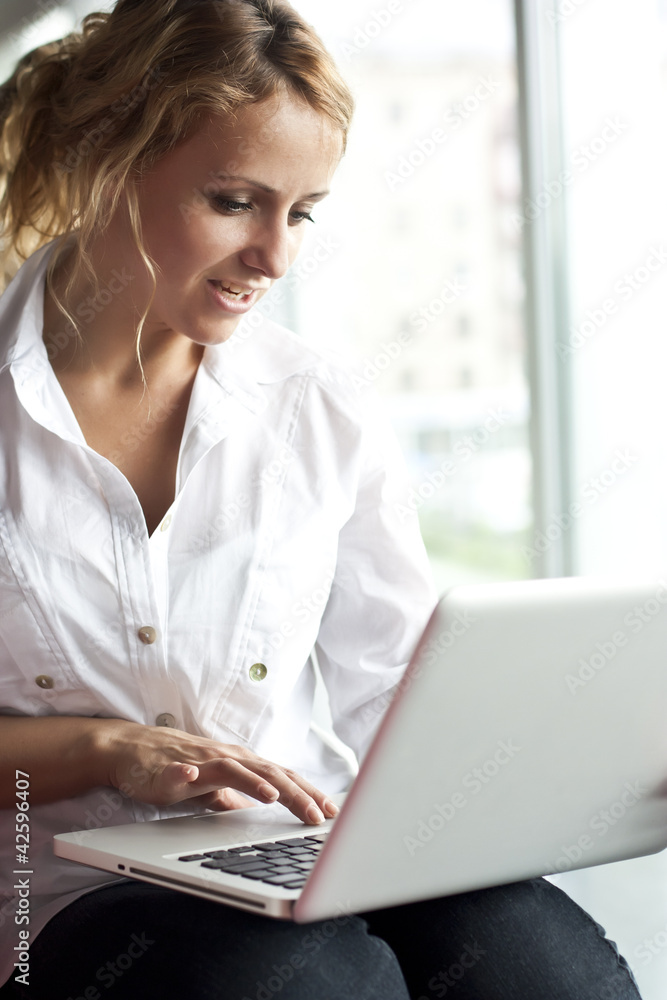 Happy young beautiful woman with laptop - indoors Happy young beautiful woman with laptop - indoors
