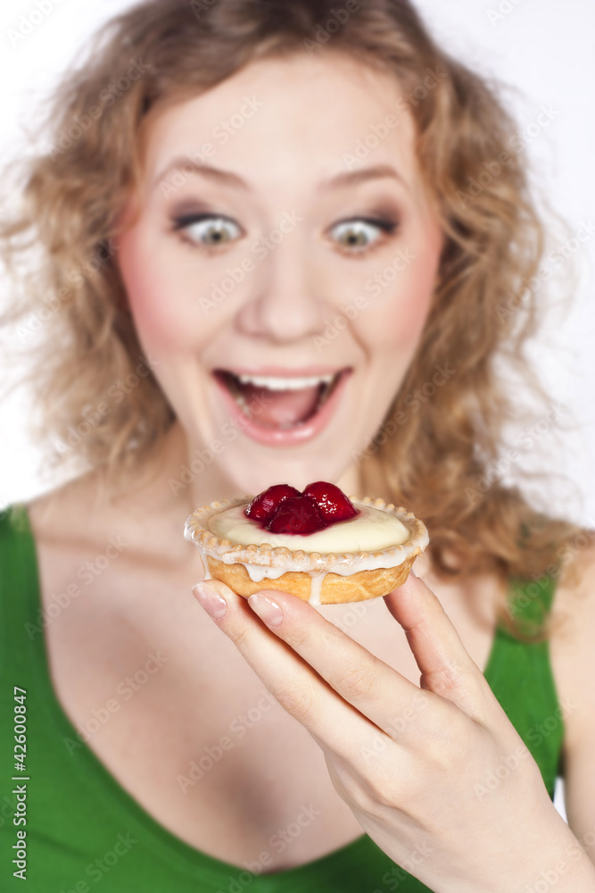 Woman eating a cake. In studio