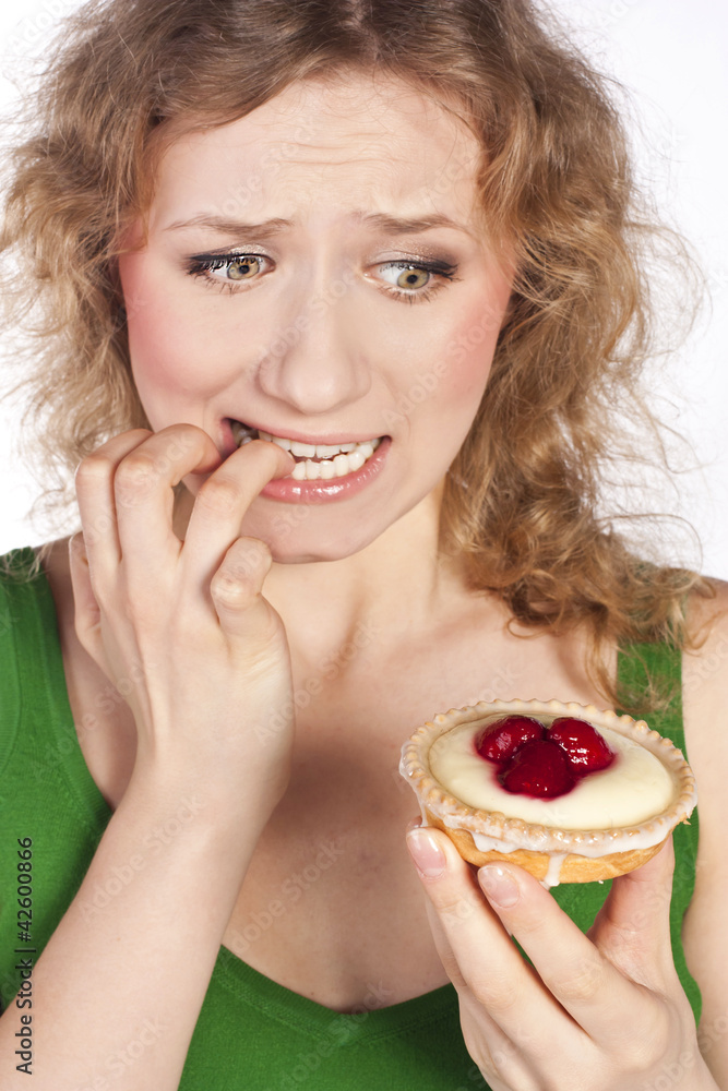 Woman eating a cake. In studio