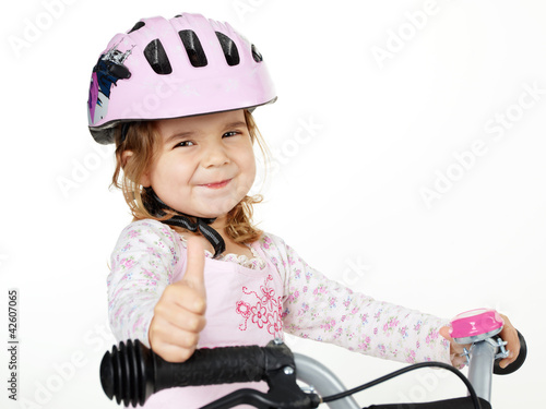Cute girl with bicycle helmet shows thumb up