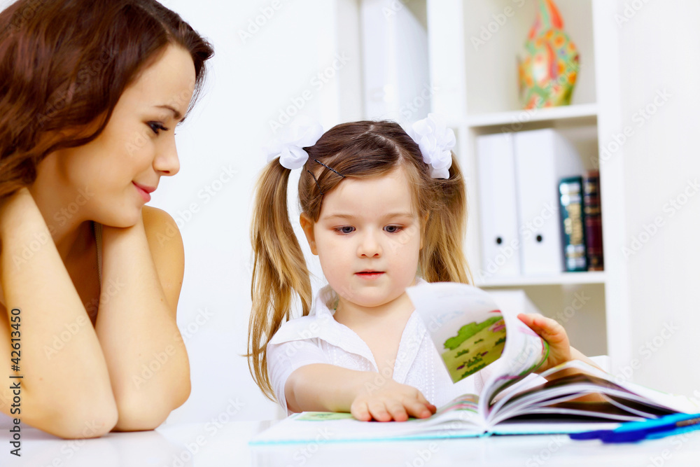 Little girl and her mother studying Little girl and her mother studying