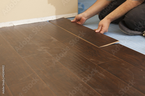 Man Installing New Laminate Wood Flooring photo