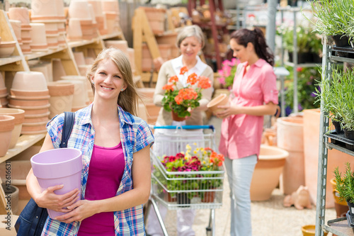 Woman holding purple pot in garden center