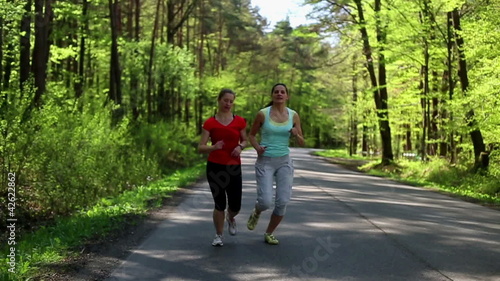 Wallpaper Mural Two happy woman jogging in the forest, steadycam, slow motion Torontodigital.ca