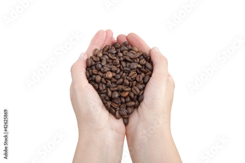 Coffee beans in human hand isolated on white