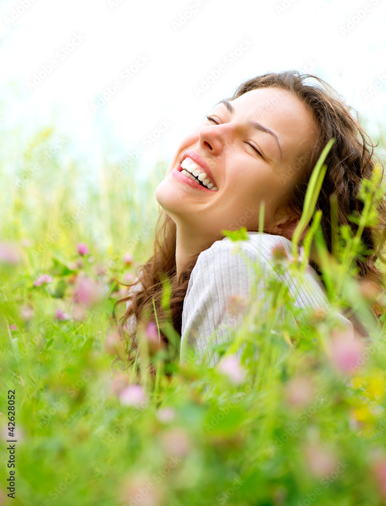 Beautiful Young Woman lying in Meadow of Flowers. Enjoy Nature Beautiful Young Woman lying in Meadow of Flowers. Enjoy Nature