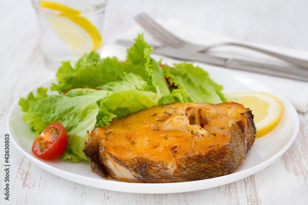fish with salad and lemon on the white plate fish with salad and lemon on the white plate
